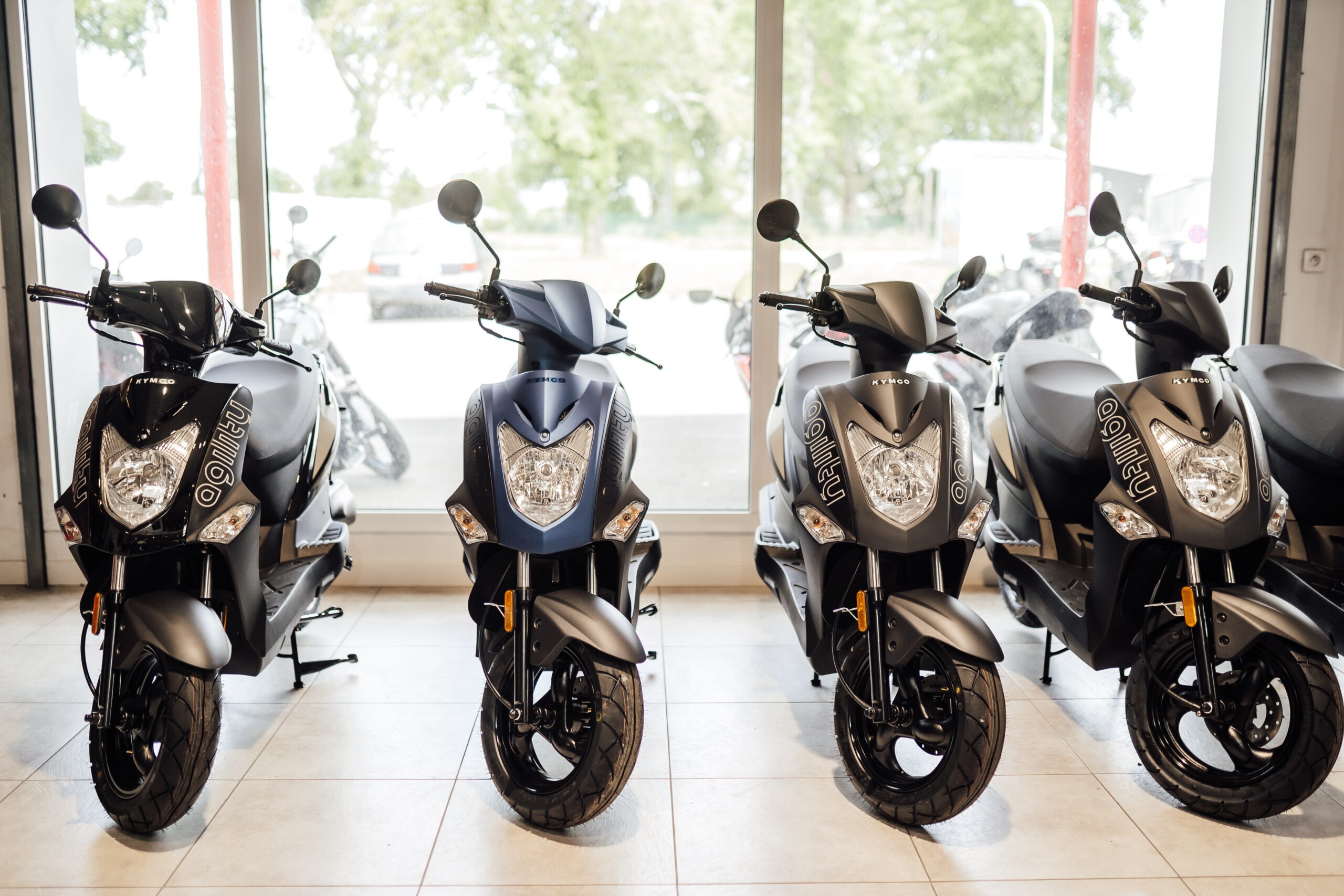 Scooters neufs alignés dans le showroom Au P'tit Bolide Moto à Redon