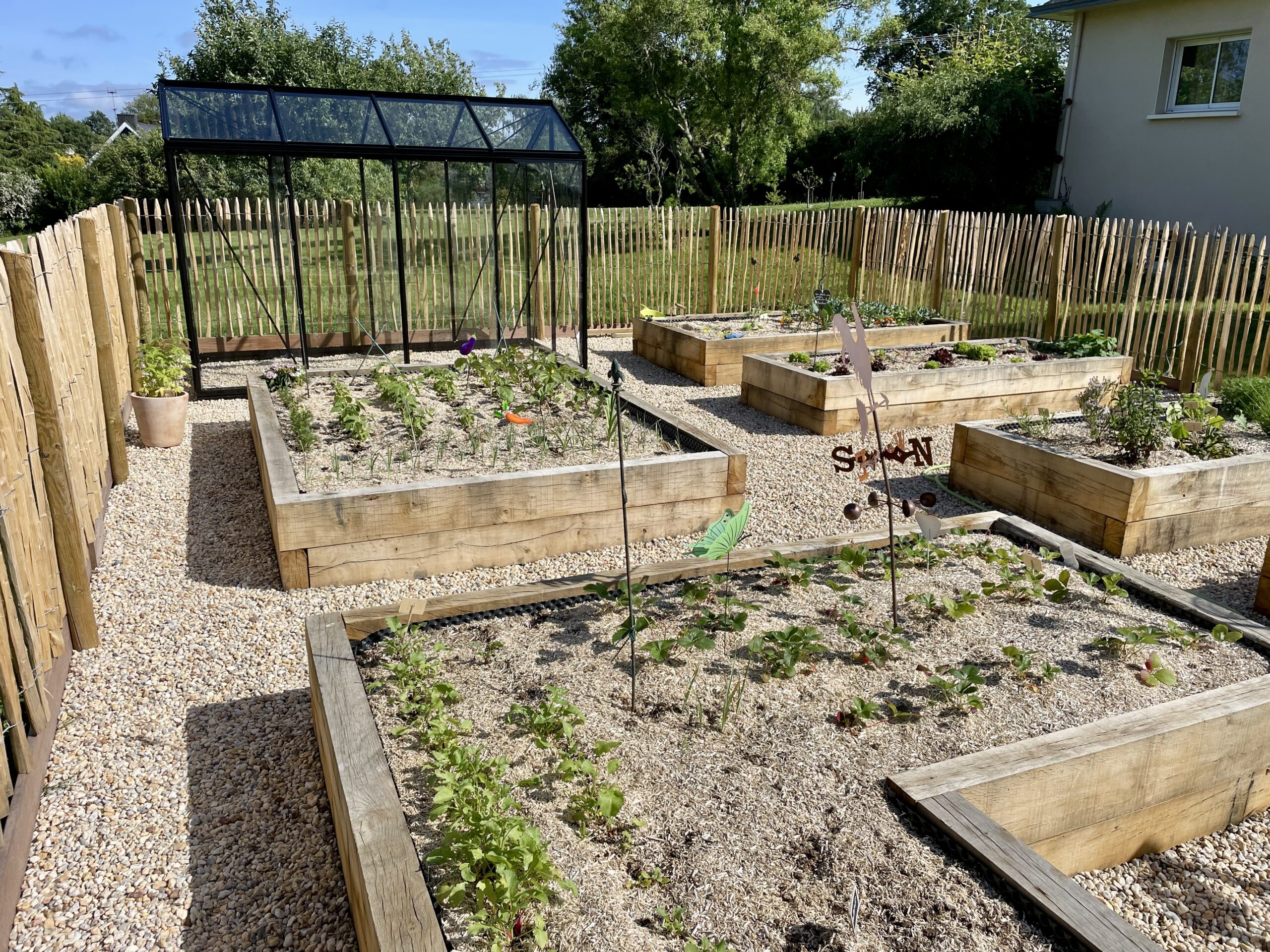 Potager surélevé en bois avec serre et clôture en châtaignier créé par Breiz Paysage