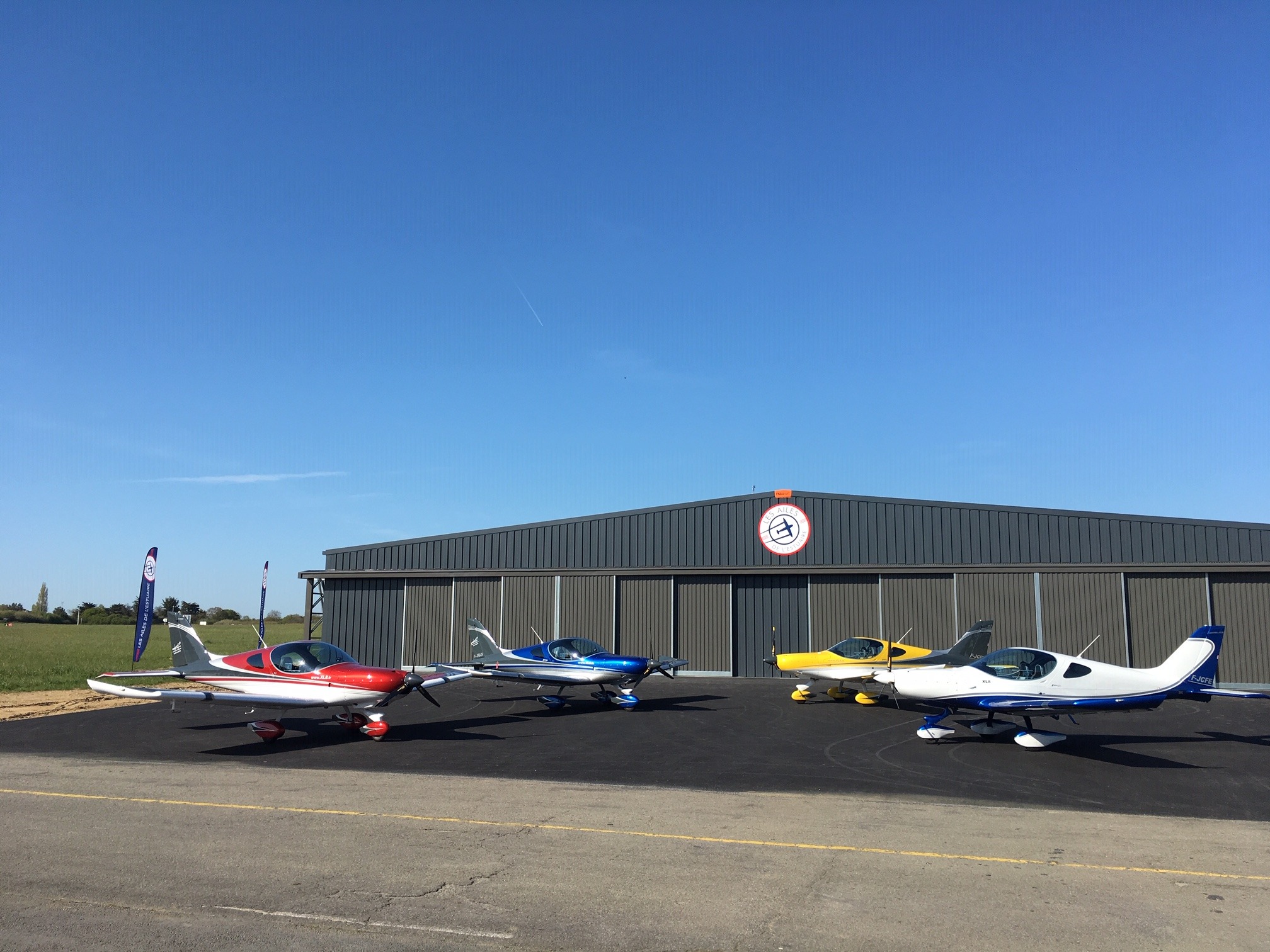 Flotte d'avions des Ailes de l'Estuaire garée devant le hangar de l'aérodrome de La Baule