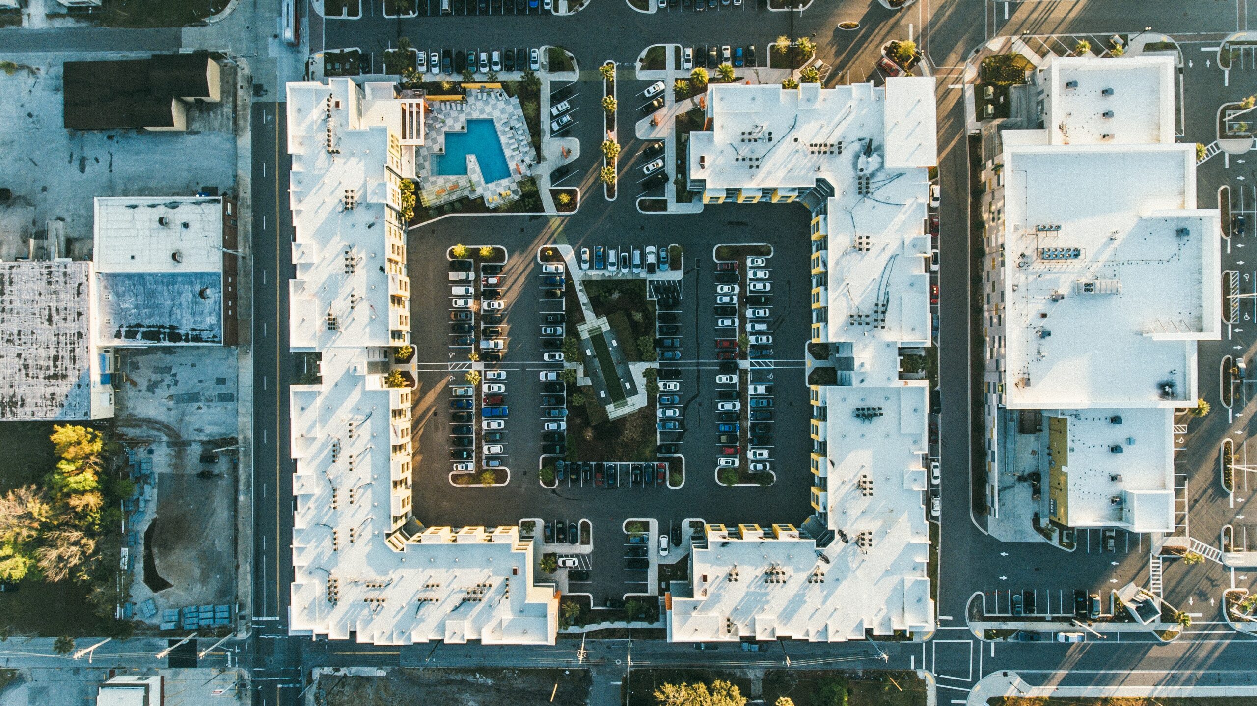 Vue aérienne d'un immeuble résidentiel avec toiture, piscine et parking, exemple d'état des lieux par drone