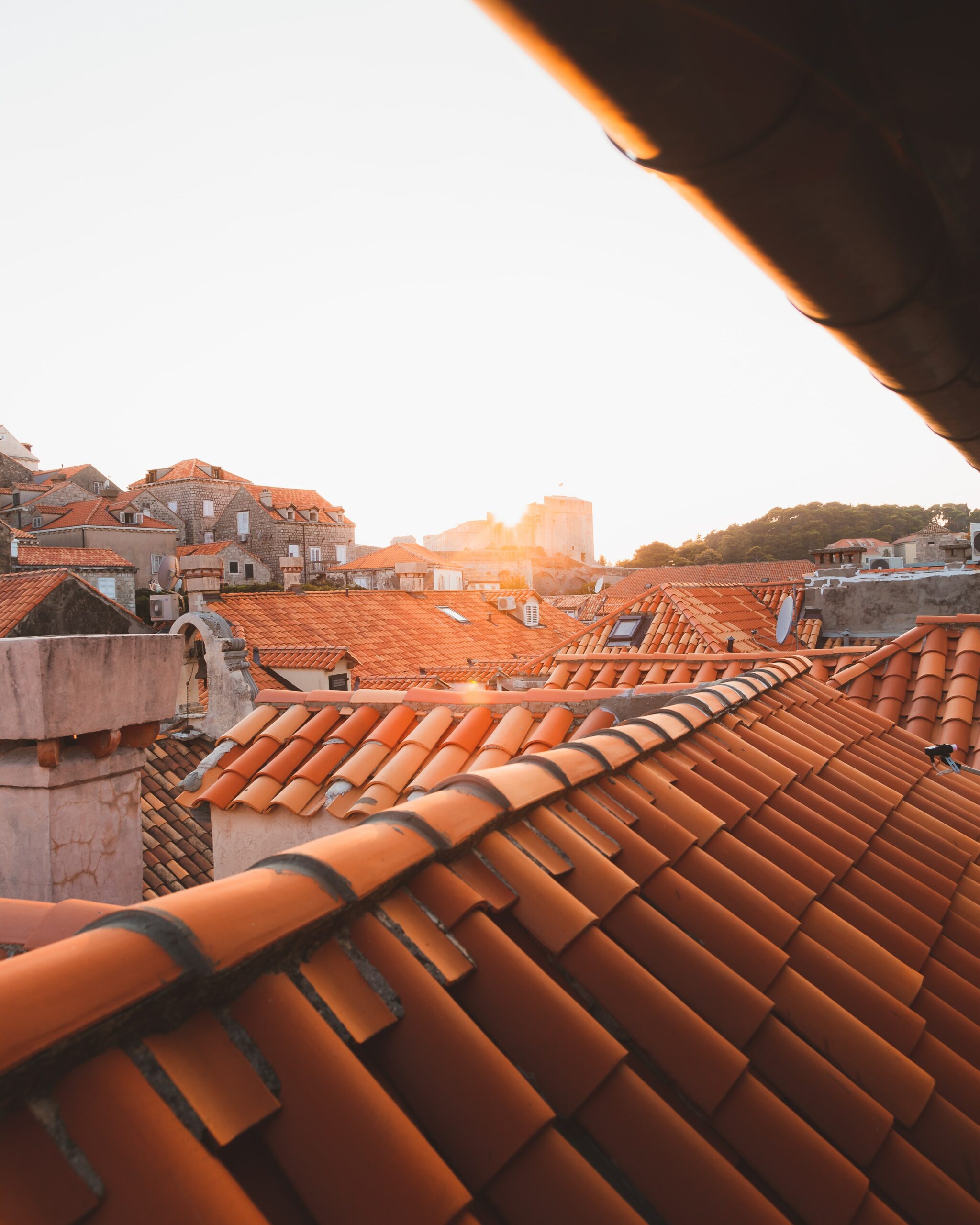 Gros plan sur une toiture de tuiles au coucher du soleil, inspection du clos et du couvert