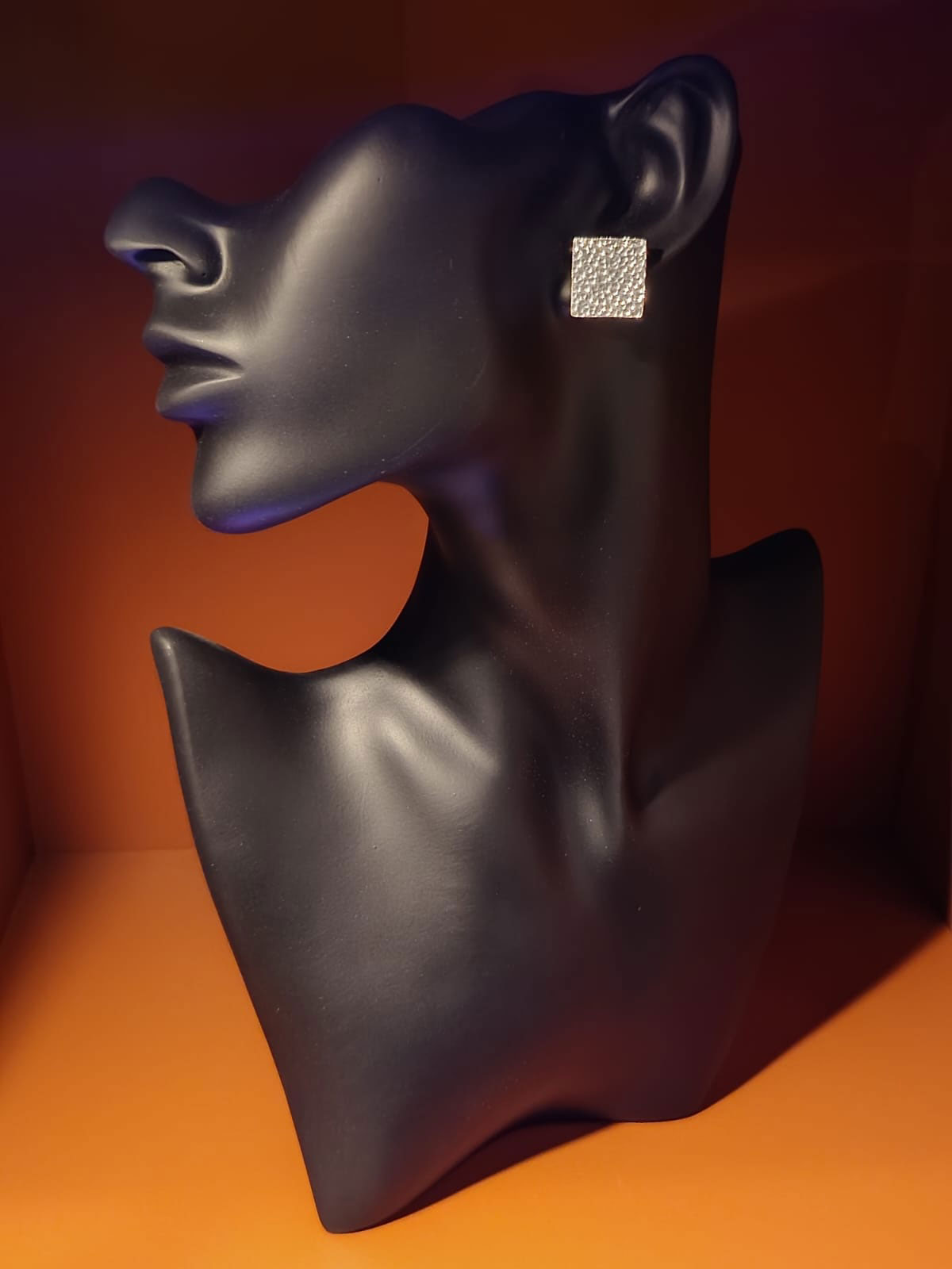 Boucle d’oreille carrée en argent présentée sur buste noir, création artisanale à découvrir sur le marché de Pornichet